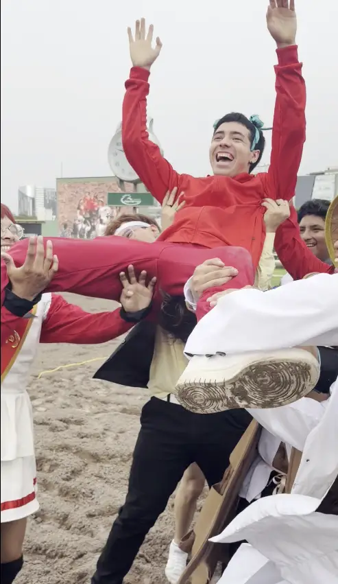 Participantes levantando a un corredor durante la celebración